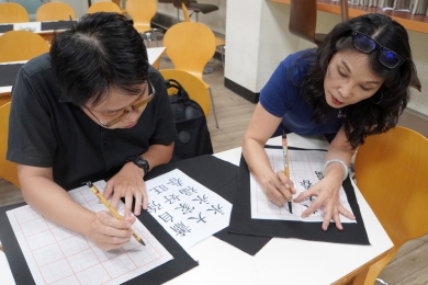 大葉國際學生寫書法，由鄧婉玲教授（右）指導。（照片大葉提供）