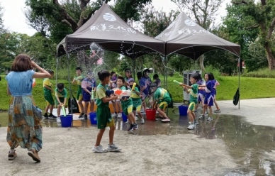 成美文化園「水花大作戰」,大姐姐小嫺(左)被小朋友集中水槍猛攻,招架不住。(記者林碧珠攝)